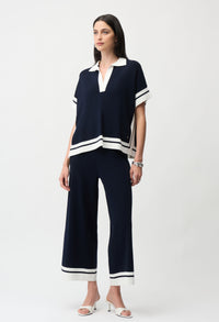 woman wearing a navy pullover with white trim and matching trousers