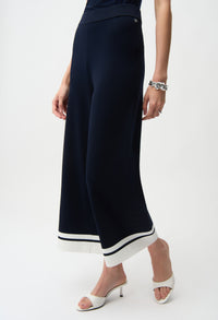 Navy wide-leg pants with white trim worn by a person on a white background