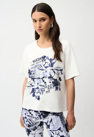 Woman wearing a white t-shirt with blue floral design on a plain background