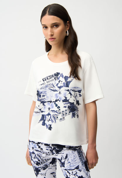 Woman wearing a white t-shirt with blue floral design on a plain background