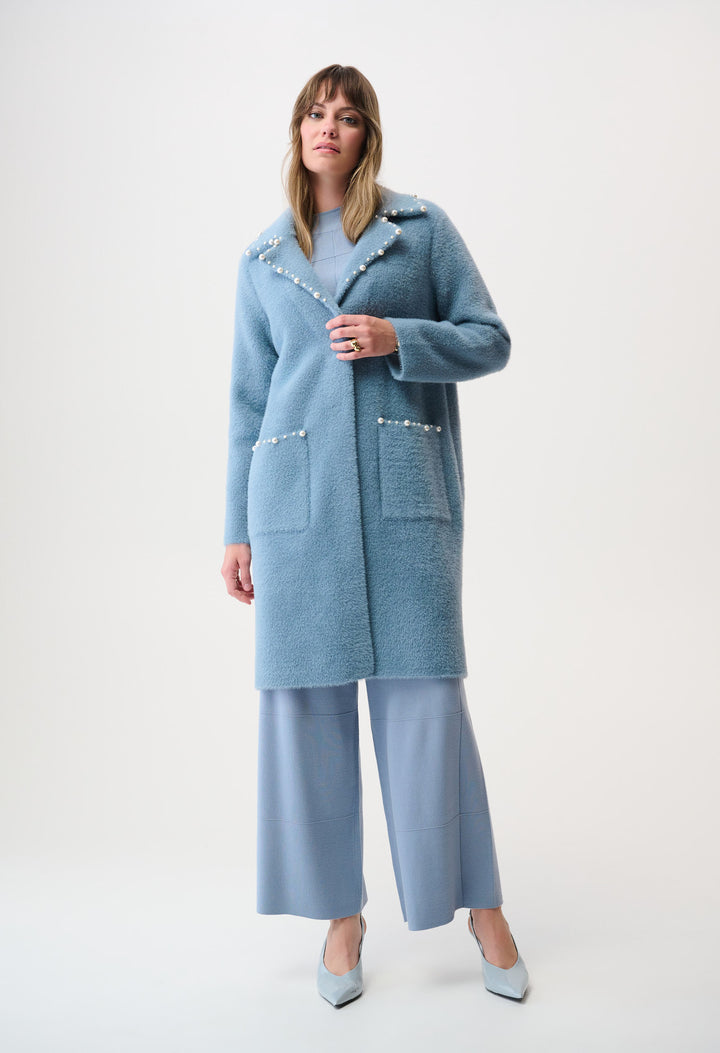 woman wearing a light blue coat with pearl details