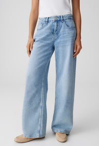 Light blue jeans worn by a person on a plain background