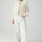 Person wearing a white outfit with a jacket and pants on a plain background