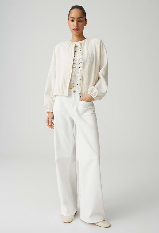 Person wearing a white outfit with a jacket and pants on a plain background