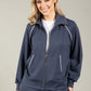 Woman wearing a navy tracksuit with white accents on a beige background