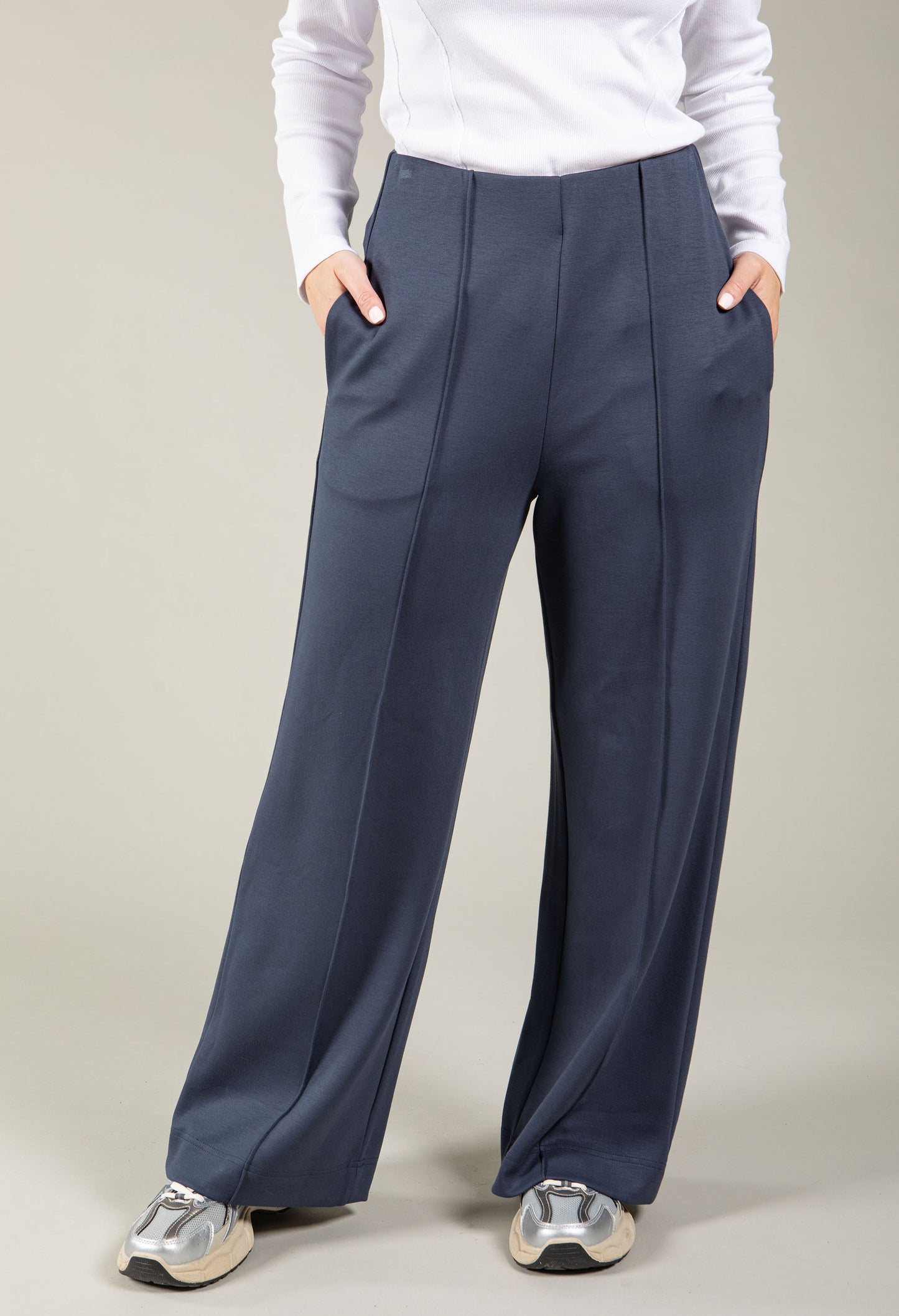 Navy wide-leg pants worn by a person on a plain background