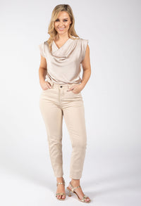 Woman wearing a beige sleeveless top and pants on a white background