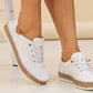 White sneakers with cork soles worn by a person on a light background