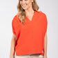Woman wearing an orange blouse against a white background