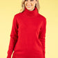 Woman wearing a red turtleneck sweater against a yellow background