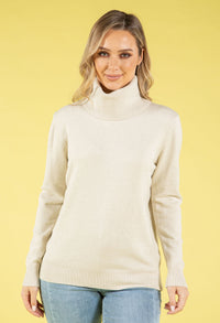 Woman wearing a cream turtleneck sweater against a yellow background
