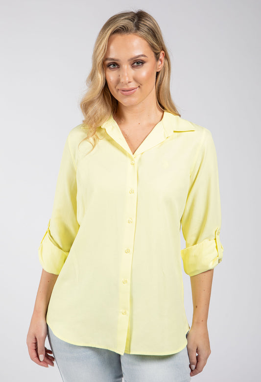 Woman wearing a light blue button-up shirt on a white background