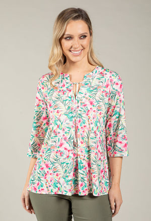 Woman wearing a floral blouse with a neutral background