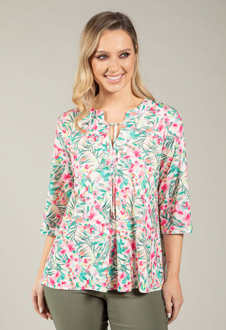 Woman wearing a floral blouse with a neutral background