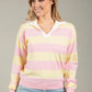 Woman wearing a pastel striped sweater against a neutral background