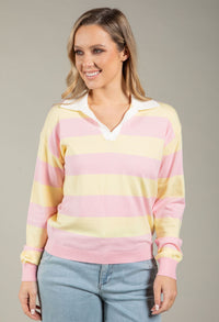 Woman wearing a pastel striped sweater against a neutral background