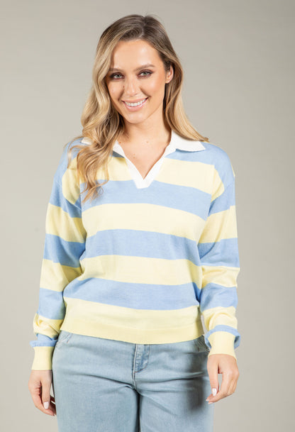 Woman wearing a blue and yellow striped sweater against a gray background