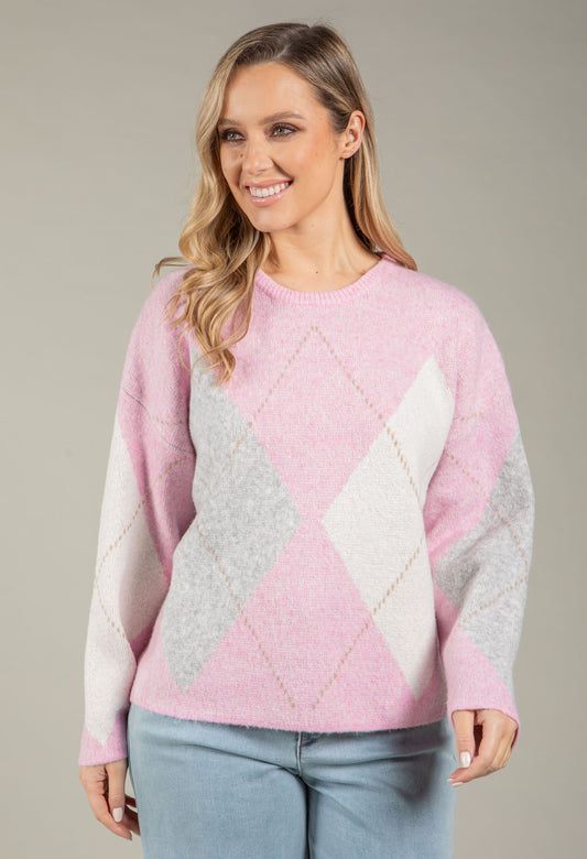 Woman wearing a light blue and gray diamond pattern sweater against a neutral background