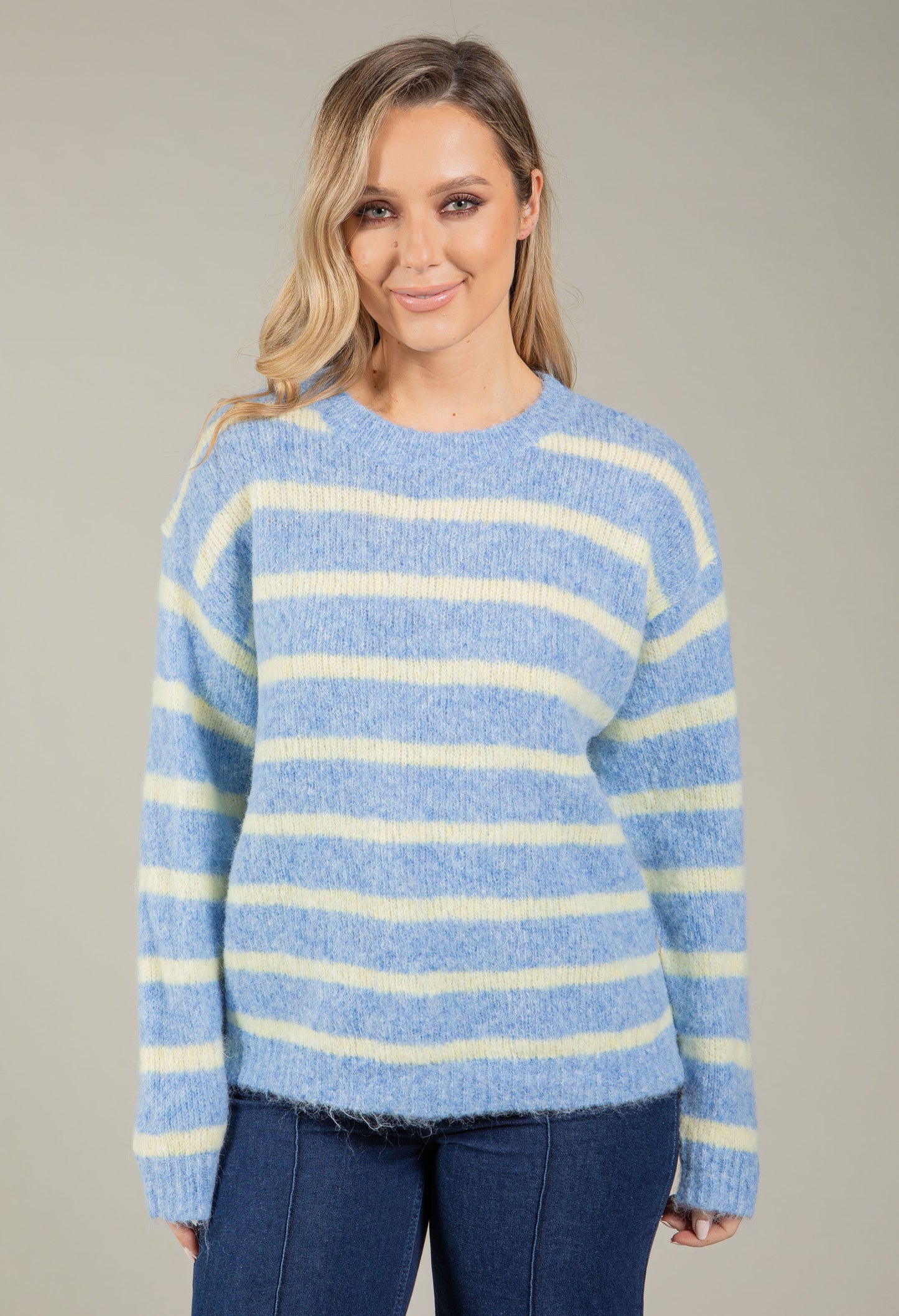 Woman wearing a blue and white striped sweater against a gray background