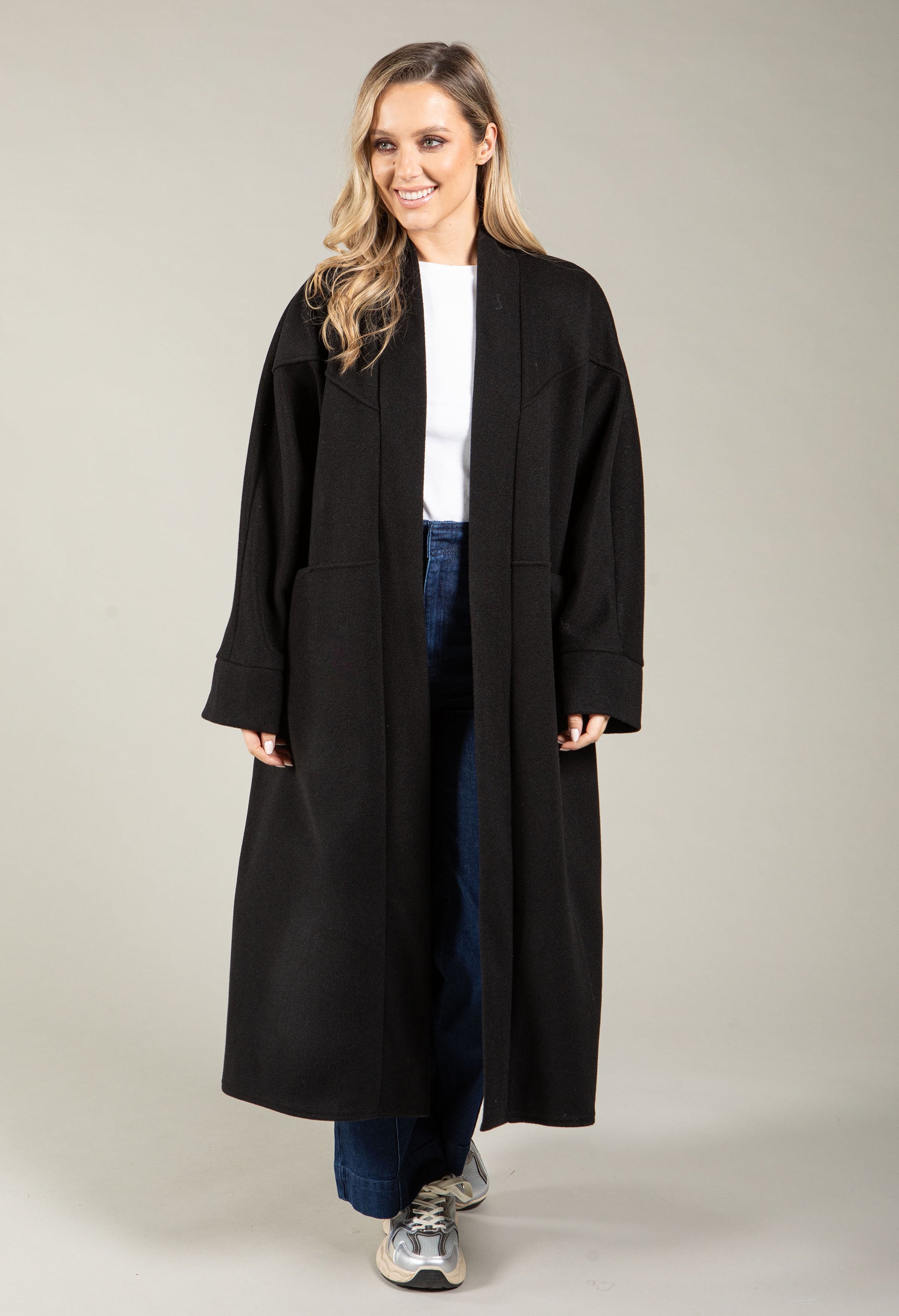 Woman wearing a black coat on a plain background