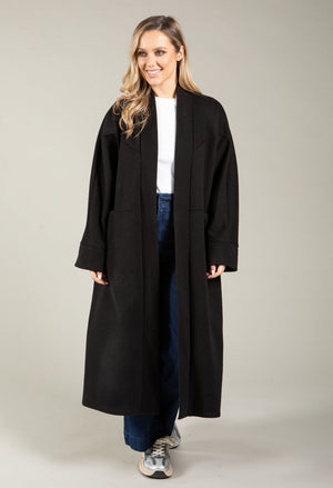 Woman wearing a black coat on a plain background