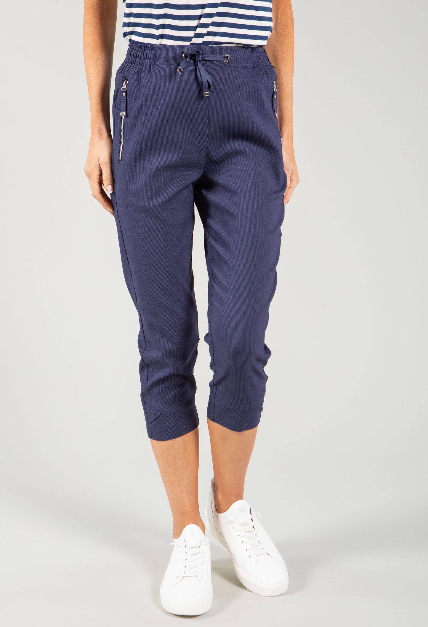 Navy blue jogger pants worn by a person on a light gray background