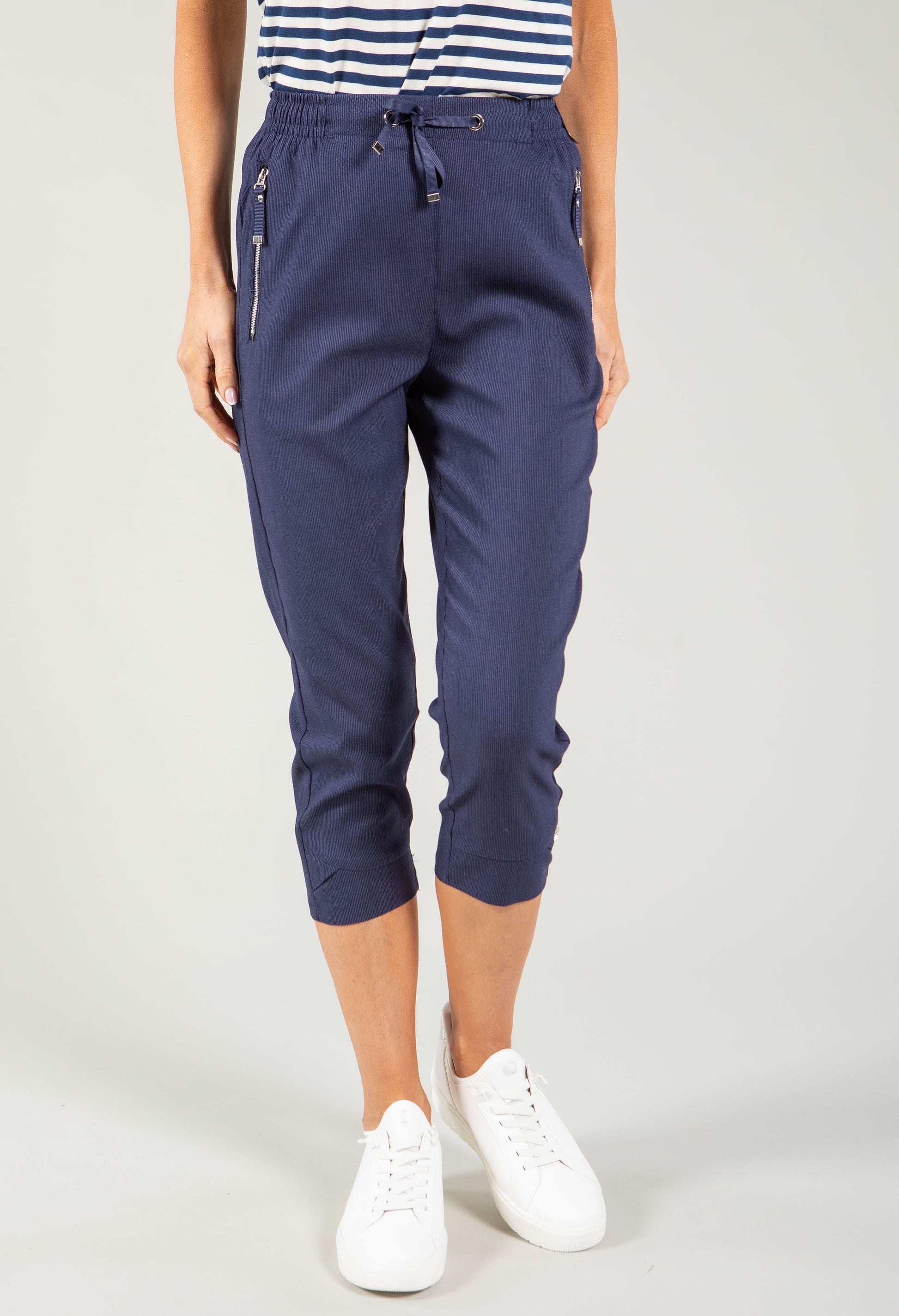 Navy blue jogger pants worn by a person on a light gray background