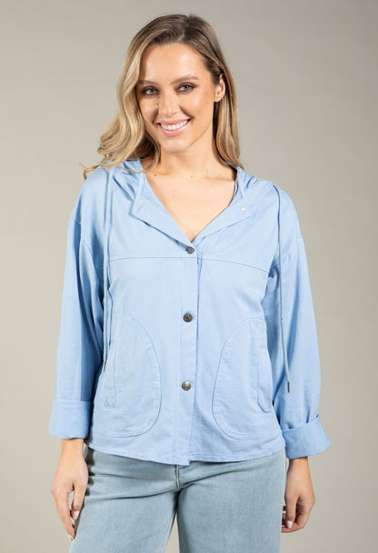 Woman wearing a light blue jacket with a neutral background