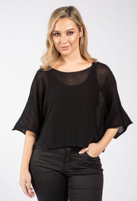 Woman wearing a black top with sheer sleeves on a white background