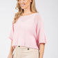 Woman wearing a pink top and beige pants on a white background