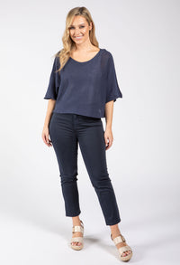 Woman wearing a navy blue top and pants on a white background