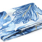 Folded fabric with blue and white leaf pattern on a white background