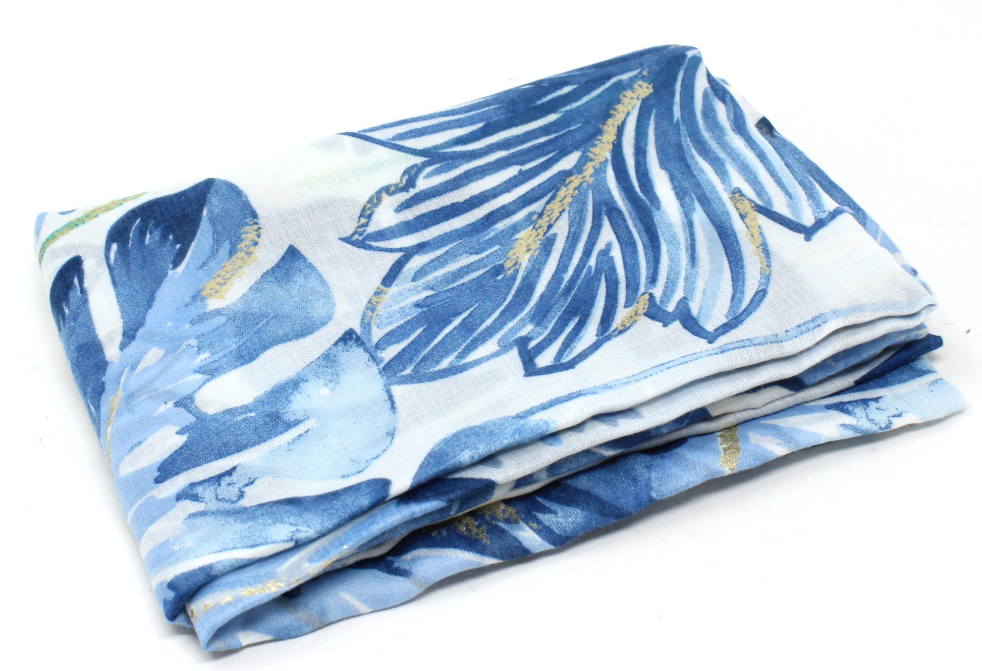Folded fabric with blue and white leaf pattern on a white background