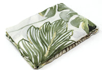 Folded fabric with green leaf pattern on a white background