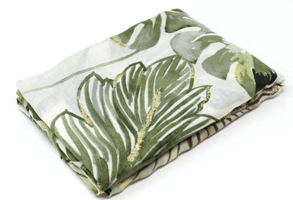Folded fabric with green leaf pattern on a white background