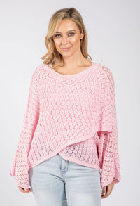 Woman wearing a pink knitted sweater on a white background