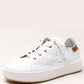 White sneaker with a textured sole on a light beige background