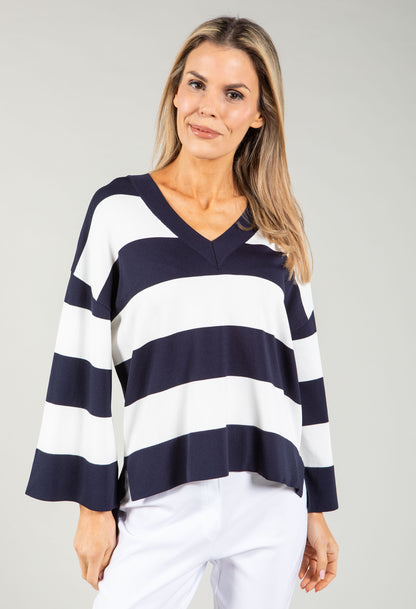 Woman wearing a navy and white striped sweater against a gray background