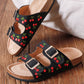Black sandals with embroidered cherry design, double straps and gold buckles