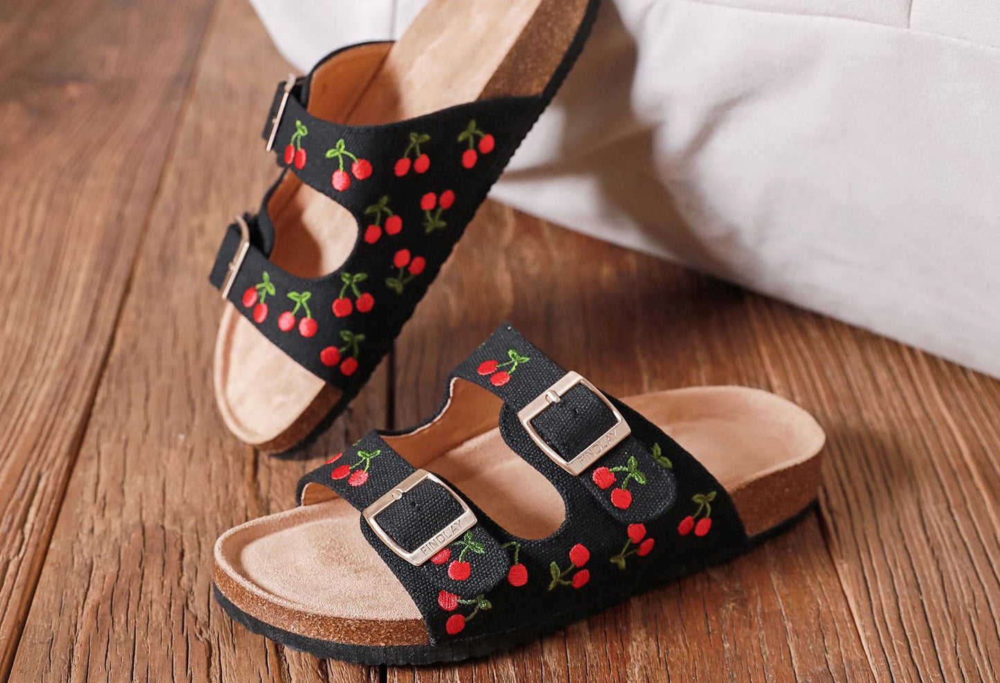 Black sandals with embroidered cherry design, double straps and gold buckles