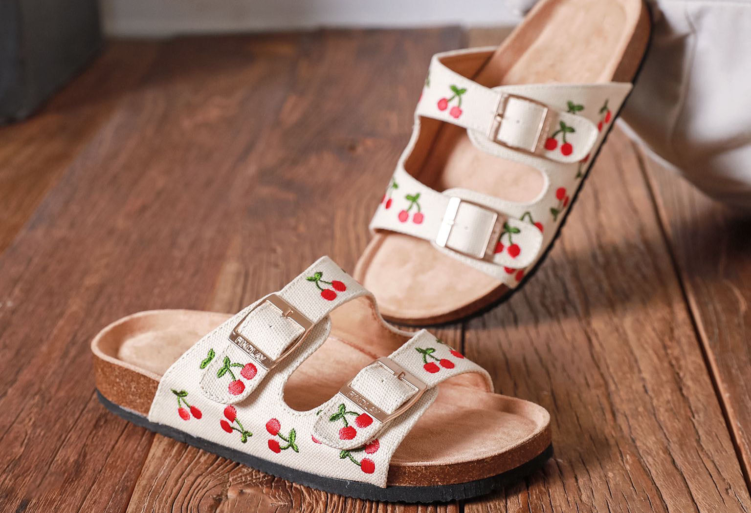 Cream sandals with embroidered cherry design, double straps and gold buckles