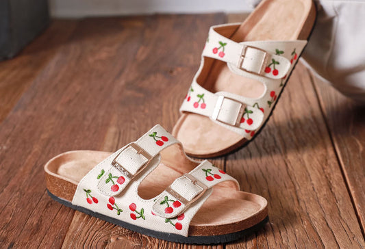 Cream sandals with embroidered cherry design, double straps and gold buckles