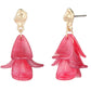 Pink flower-shaped earrings with gold hooks on a white background