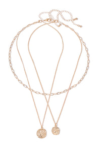 Rose gold necklace with two pendant charms on a white background