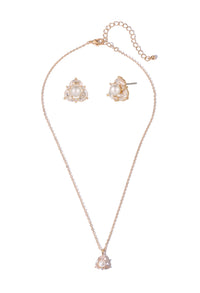 Rose gold necklace and earrings set on a white background