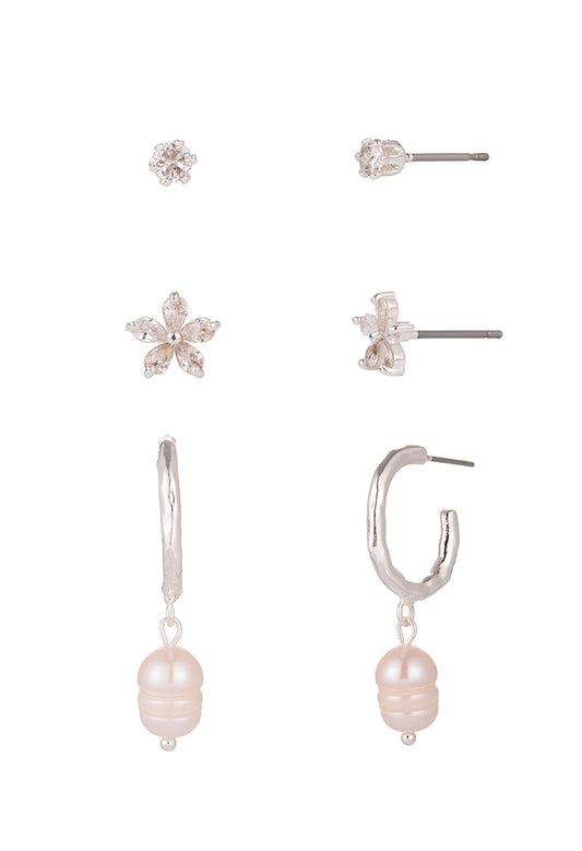 Set of earrings including floral, hoop with pearl, and other designs on a white background