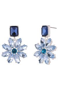 Pair of blue flower-shaped earrings with gemstones on a white background
