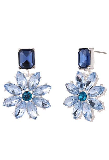 Pair of blue flower-shaped earrings with gemstones on a white background