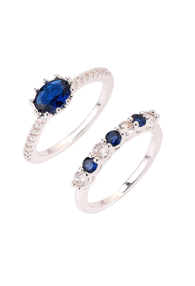 Two silver rings with blue gemstones on a white background