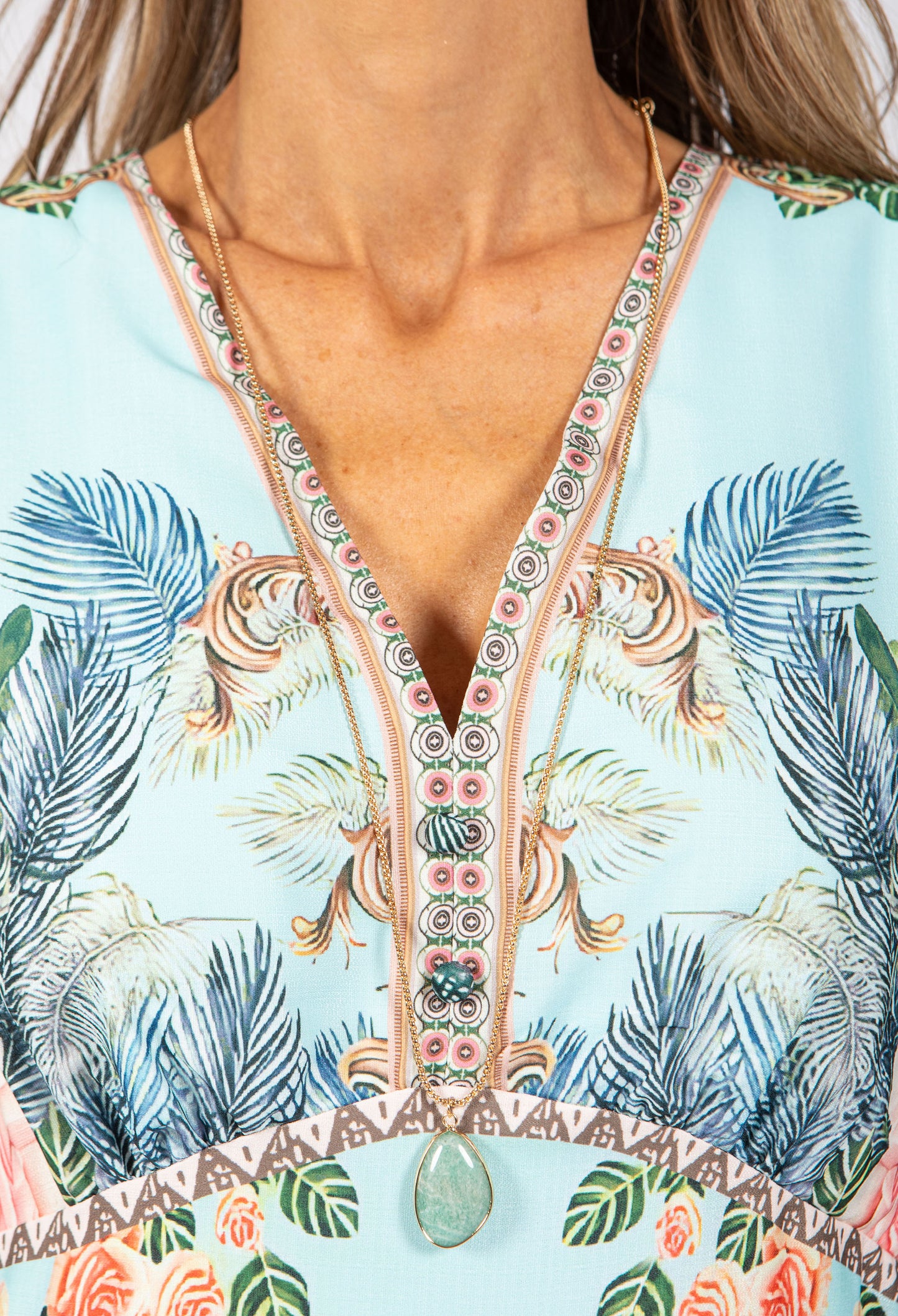 Close-up of a colorful dress with floral and palm tree patterns.